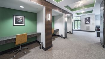 a hallway with a green wall and a desk with a chair at The Hendrix, Atlanta